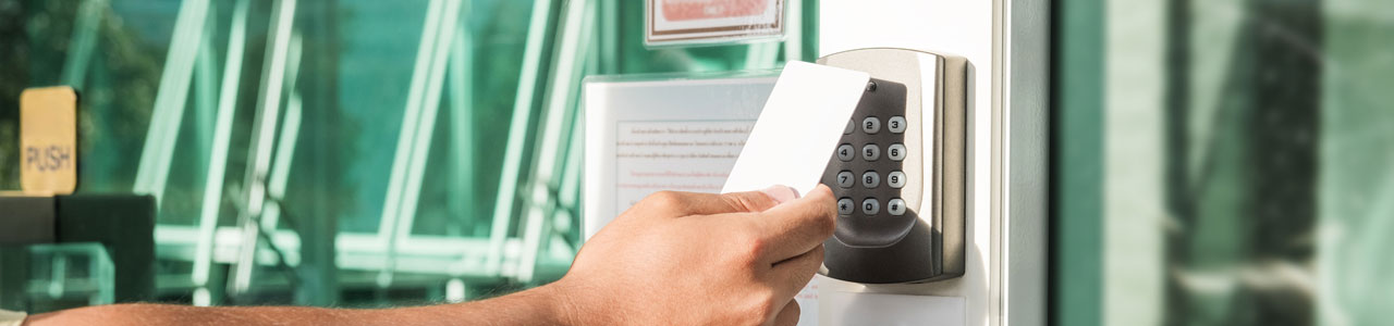 Hand using security key card scanning to open the door to entering private building. Home and building security system